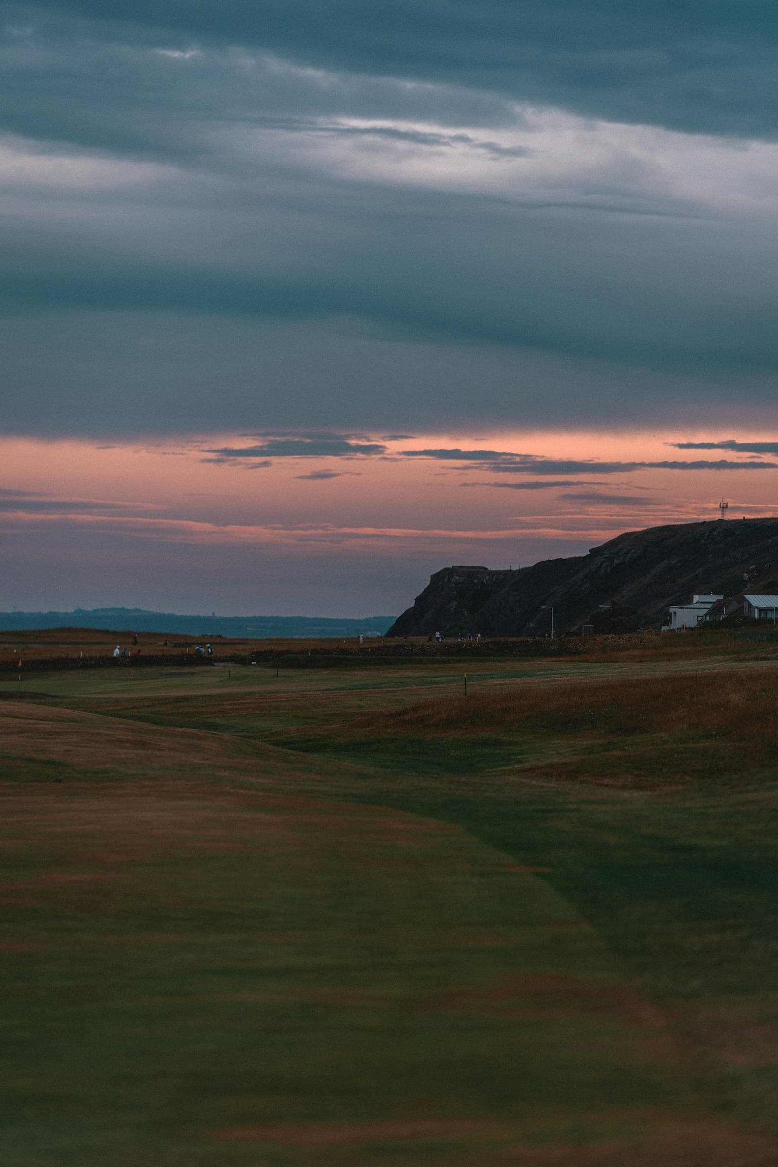 A links fairway at dusk, a headland against the last of the light